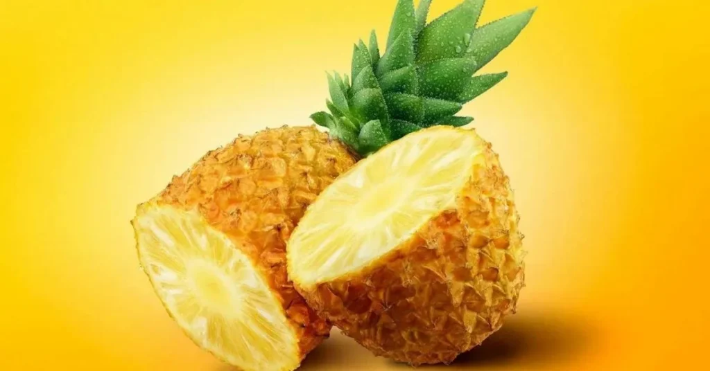 A vibrant pineapple is halved, showcasing its juicy yellow interior against a bright yellow background.